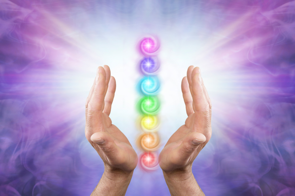 Two hands giving reiki energy to balance the chakras and energy.