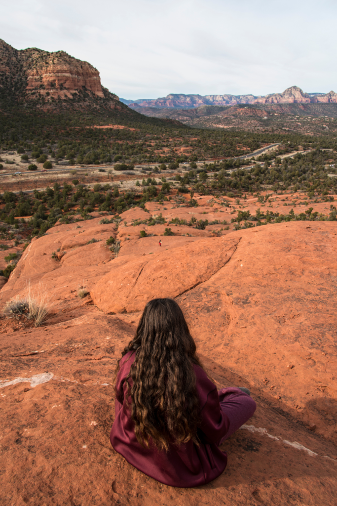 Woman siting in Arizona desert to ground, meditate and feel calm. She is reducing her depression, anxiety and stress through nature immersion.