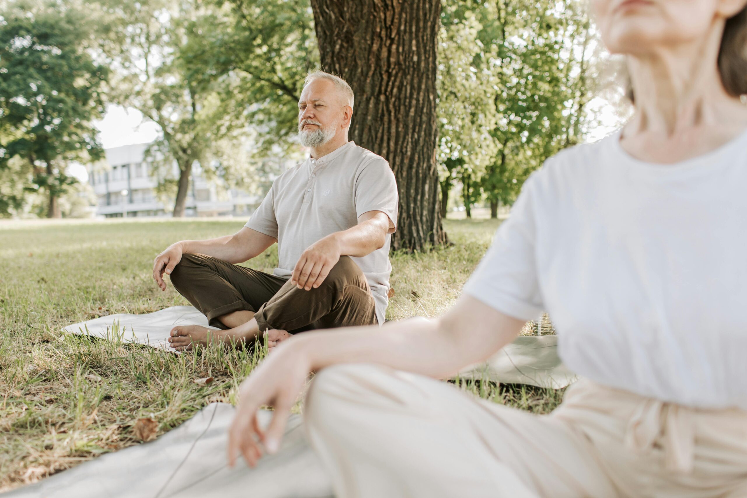 Older man and woman sitting doing breathwork for relaxation.